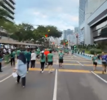 KLマラソン2025・5km、緑のTシャツのランナーが都心の大通りを進む様子